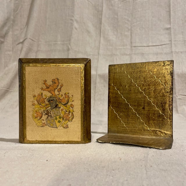 A regal pair of Italian Florentine bookends, coat of arms family crest with griffin and shield with acanthus foliage. Gold...