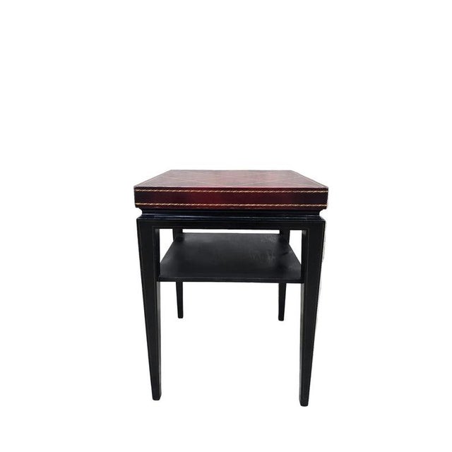 Hollywood Regency design distinguished by a two-inch-tall leather-clad top with cordovan color craqueler finish and finely...