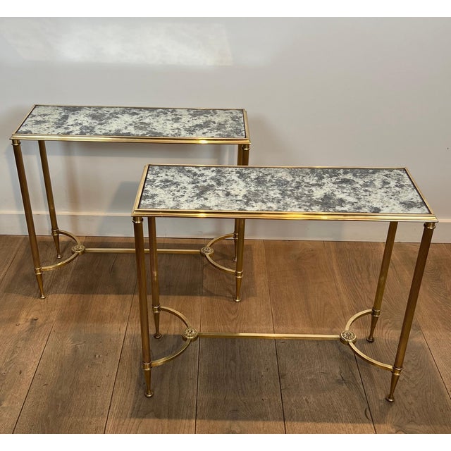 This magnificent pair of neoclassical-style side tables is made of brass with oxidized mirror tops. The base features a...