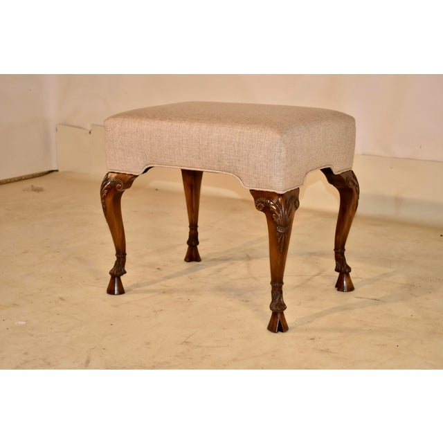 Early 19th century hand carved walnut stool with newly upholstered seat from England. The seat has been newly upholstered...