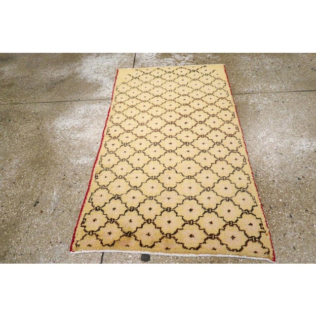 A vintage Turkish Anatolian throw rug. The ivory field displays a brown cartouche lattice which starts a bit uncertainly...
