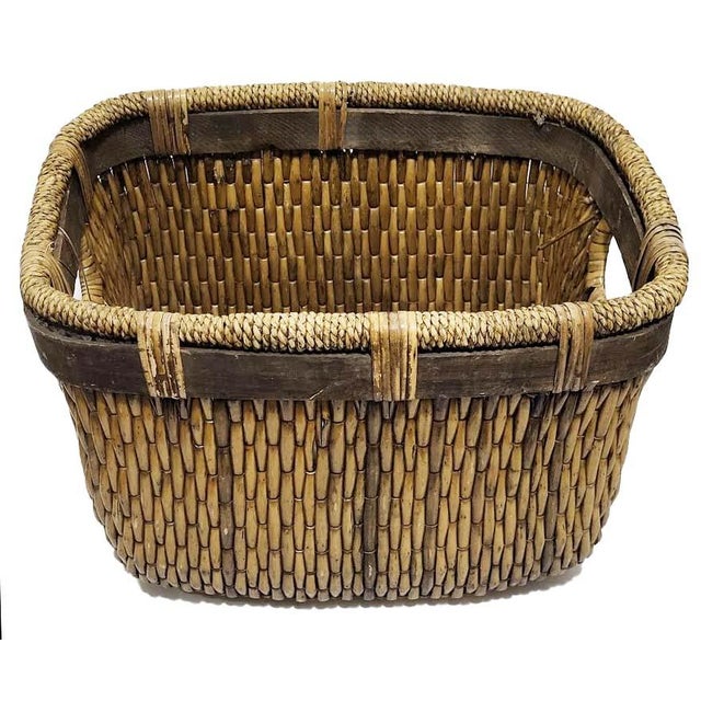 Large rustic market basket made of woven rattan, a natural and durable material. Wood trim along top adds a nice touch and...