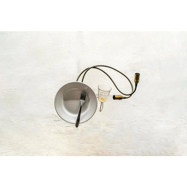 Applique con struttura in ottone decorata con bicchiere in vetro, piatto in ceramica e posata in acciaio. Modello Servito...