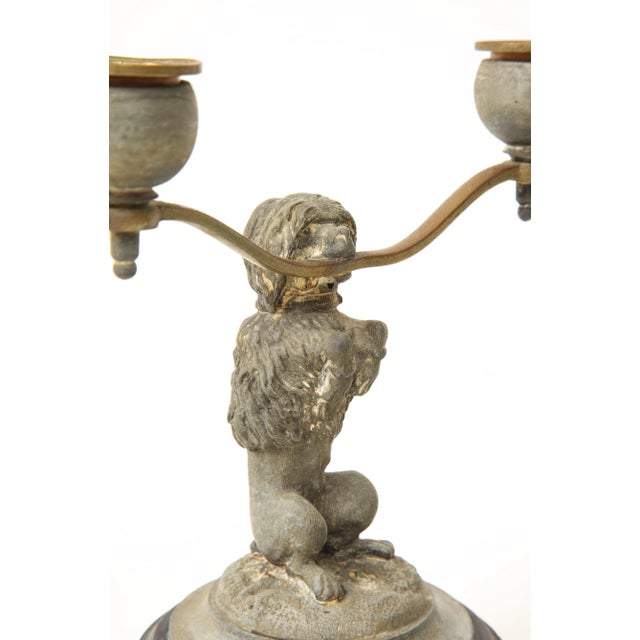 Each with seated dog supporting the two candle holders; on black turned base. From the Collection of Mario Buatta, New...