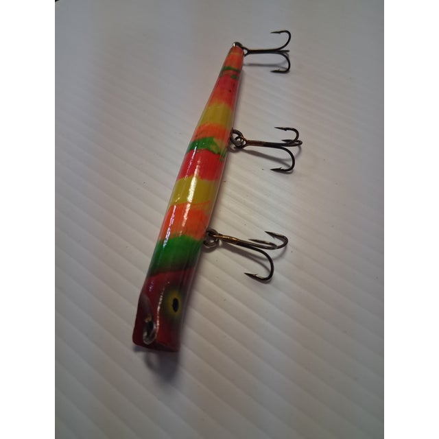 This item is a vintage, hand-painted, wooden pencil plug fishing lure, commonly used for targeting walleye or bass. It...