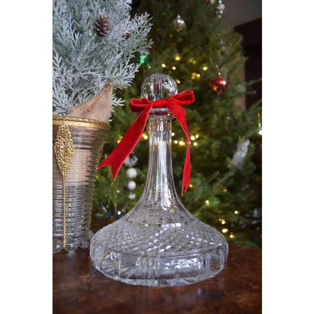 Hand-cut Polish lead crystal decanter featuring a wide baluster form, deep diamond and fan cutting, and a tall flared neck...