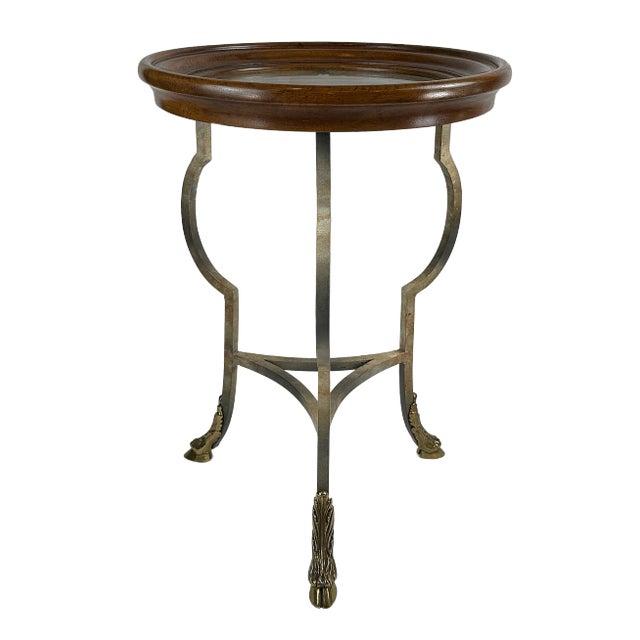 This is a 1980's Drexel Furniture round side table. This table features an aged pewter finished iron base with "Pied De...