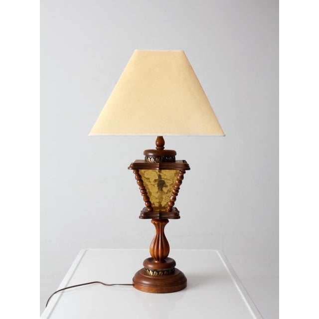 Vintage Mediterranean Revival table lamp featuring faceted amber textured glass, turned wood detailing, and dark metal...