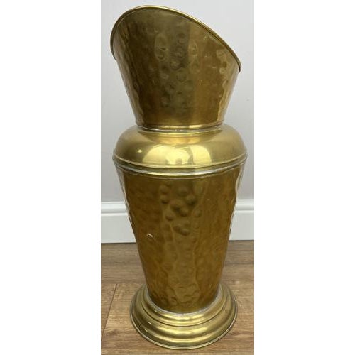 An elegant vintage brass umbrella holder featuring a beautifully shaped form with a decorative hammered finish and...