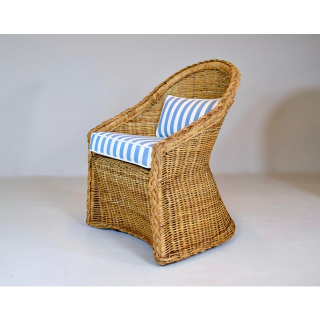 An exceptional pair of vintage braided wicker rattan armchairs with new custom seat cushions and goose down bolsters,...