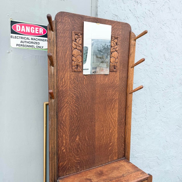A handsome antique hall tree crafted in richly figured tiger oak, showcasing dramatic grain throughout its tall...