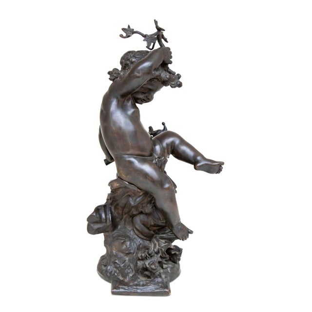 After Auguste Moreau (French, 1834-1917) "Putto" Patinated Bronze Sculpture, the seated figure upholding a vine branch and...