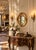A charming Victorian-era antique oval mirror featuring a beautifully molded giltwood frame adorned with raised clusters of...