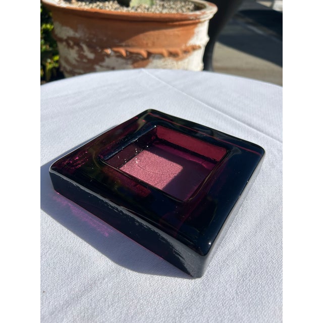 Vintage plum-colored glass catchall featuring a bold square form with a recessed interior well. The richly saturated plum...