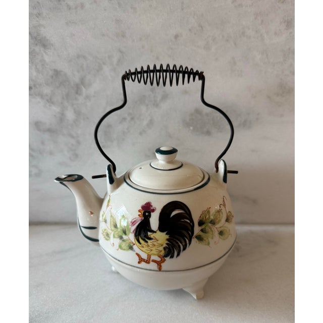 Vintage Japanese three footed tea pot with wire handle and featuring a hand painted rooster and sunflower design....