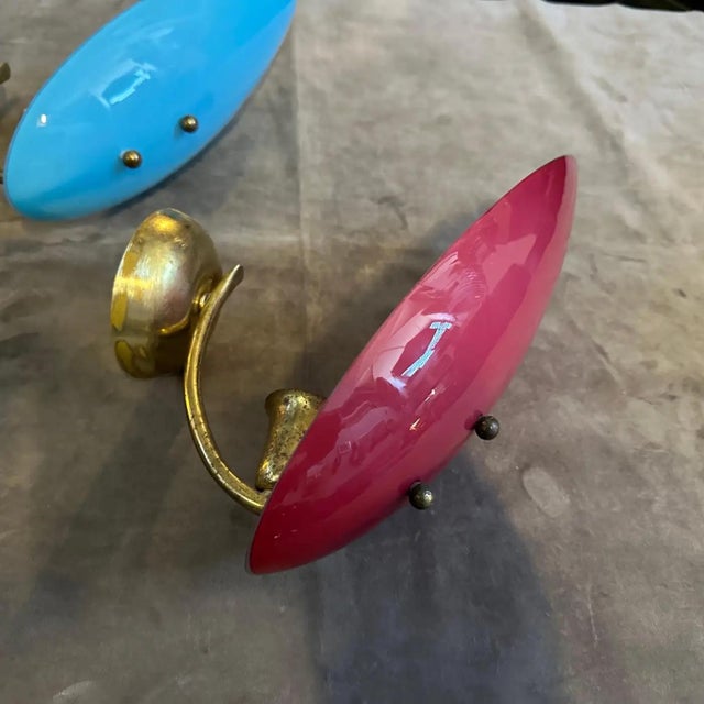 A Pair of 1950s Mid-Century Modern Italian Wall Sconces in Brass and Opaline Glass Add a bold splash of vintage Italian...
