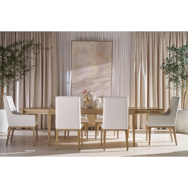 The Dining Table carries a pale Coastal Grey across a broad rectangular top, the grain running lengthwise through it and...