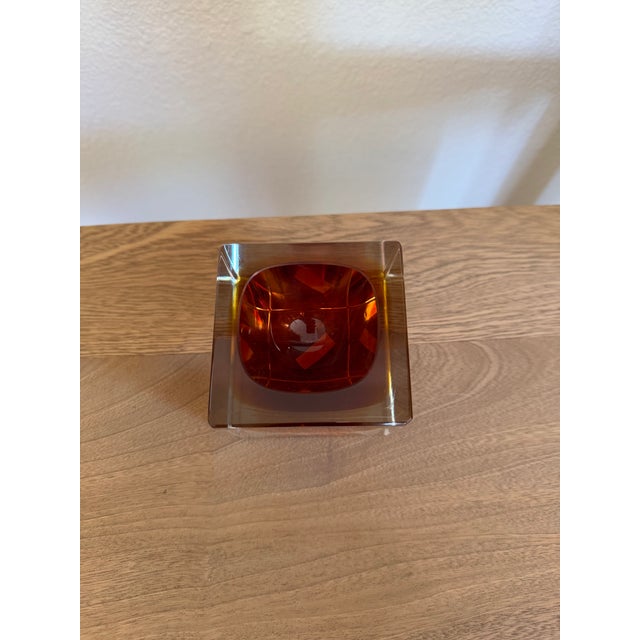 A small sommerso catchall in faceted Murano glass — an amber and orange core suspended inside a thick clear casing....