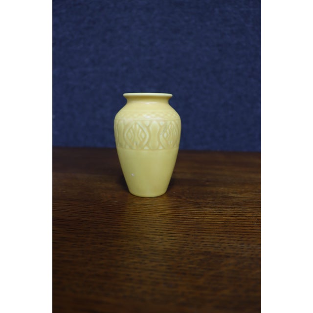Rookwood Pottery vase in a soft matte yellow glaze, featuring a rounded body with a raised geometric and stylized floral...