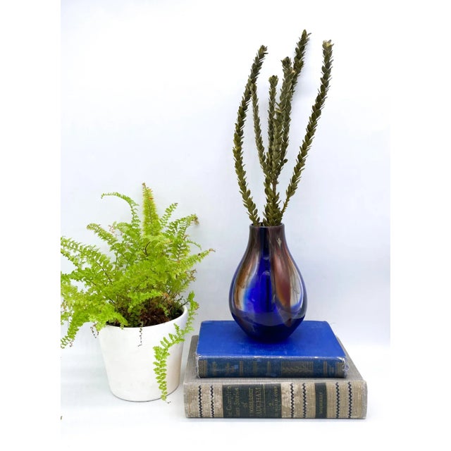 Exquisite hand blown glass vase that is signed and numbered by the artist. Stunning cobalt and brown colors swirling in...