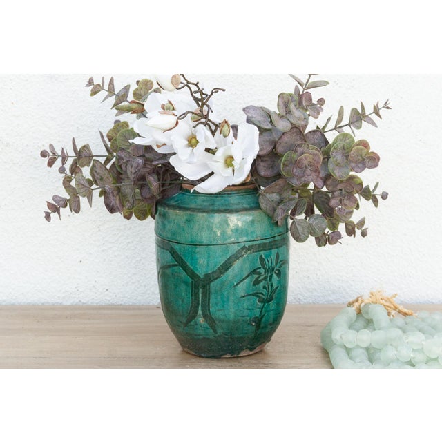 A vintage beautifully glazed porcelain vase with a flower design. This vintage Asian pottery piece has a cylindrical shape...