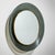 Elegant round wall mirror featuring green-tinted glass with brass accents, designed by Max Ingrand for Fontana Arte. The...