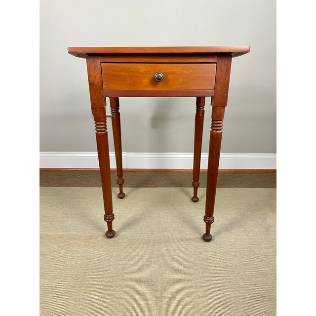 A mid-19th century cherry side table with turned legs and distinctive compressed bun feet. Solid cherry construction...