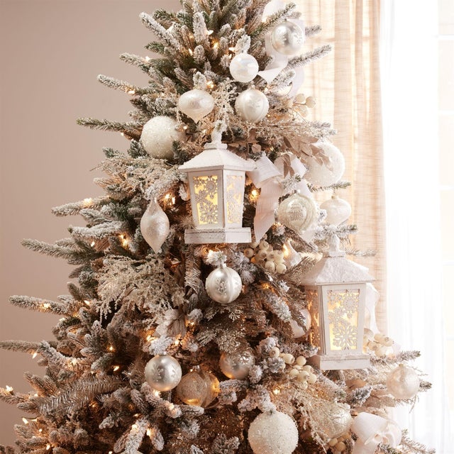 Create a warm and inviting holiday glow with this LED Winter Lantern. Designed in wintry white tones with a snowy flocking...