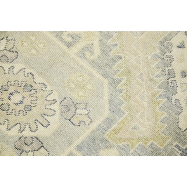 This modern Turkish Oushak rug is a stunning piece of art that has been handwoven using traditional techniques by skilled...