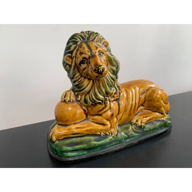 1950s Enesco majolica, ochre yellow and green, resting lion with ball under paw. A great decorative item of majolica in...