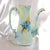 This is a blue green Tressemanes and Vogt Limoges teapot or chocolate pot that does not have a lid. It has a pattern of...
