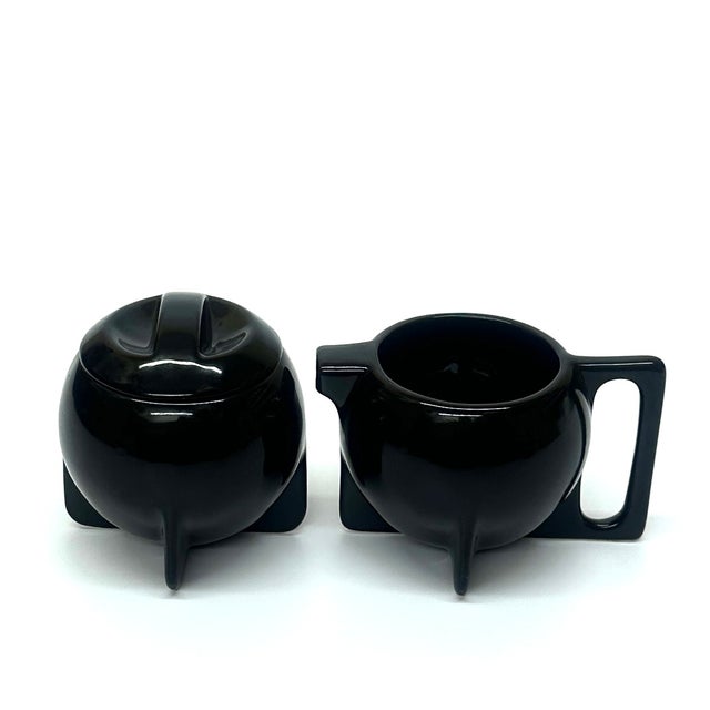 This vintage 1980s Bauhaus Revival sugar bowl and creamer set by Cowan Pottery features a sleek black lidded design with...