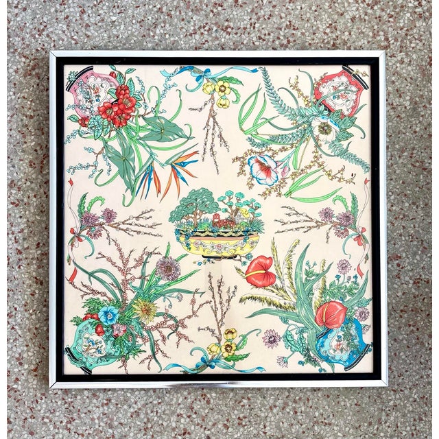 This piece is a lively and intricate botanical design framed neatly within a square border. The cream background allows...