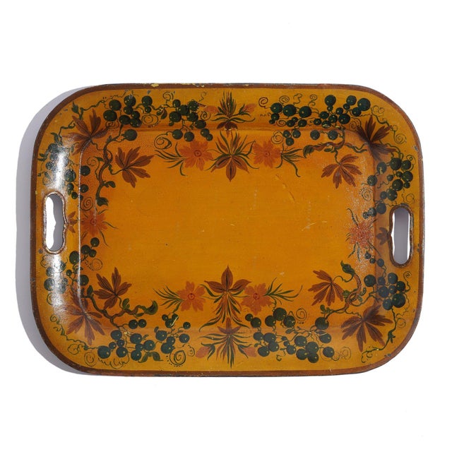 Tole tea tray with rolled rim pierced with handle grips. The tray has been hand painted with trailing flowers and foliage...