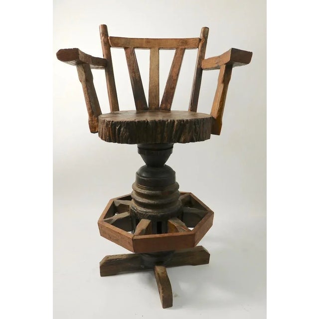 Pair of rustic, Adirondack style swivel stools, of massive center post and rough hewn wood construction. Offered and...