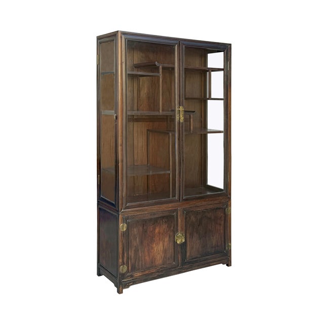 This two-part Chinese display cabinet is crafted from a dark, richly grained wood with a warm, aged patina. The upper...