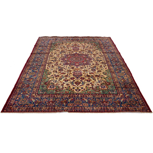 Enhance your space with this stunning Antique Tabriz Handmade Wool Rug, showcasing a tan field with vibrant green, red,...