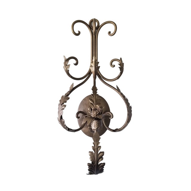 Large scroll and acanthus leaf wall sconce with a golden bronze finish. The decorative sconce has entry and exit points...