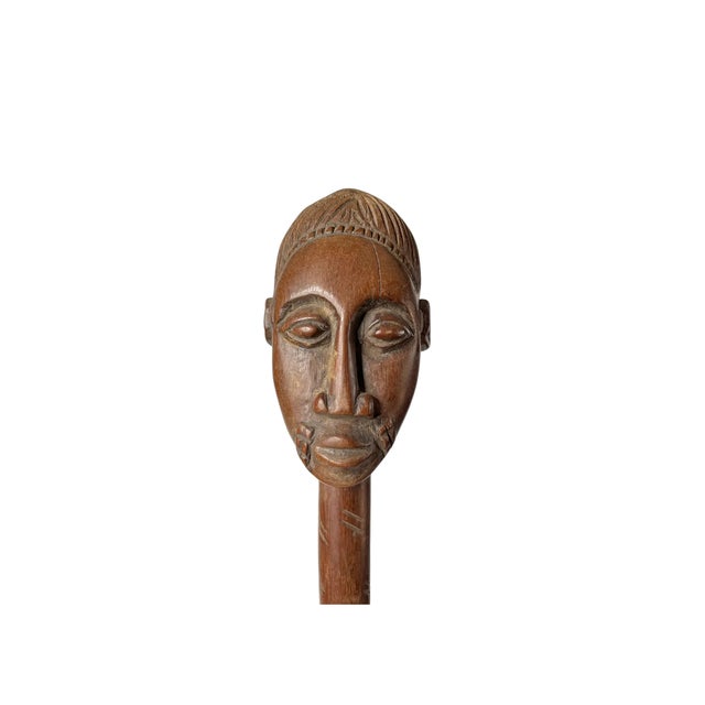 A large ceremonial spoon from West Africa. Carved with a traditional Baule face bearing an elaborate hairstyle and...