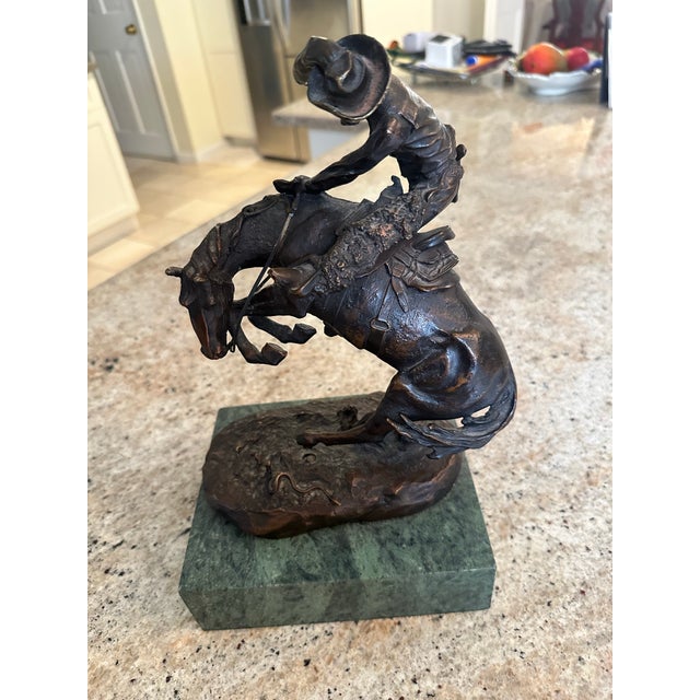 A beautiful high quality replica of “The Rattlesnake” by Frederic Remington set on a green marble base.