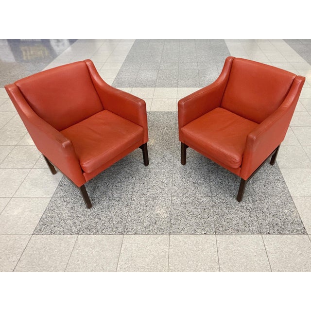 These Børge Mogensen-style lounge chairs were made in Denmark in the 1960s. They have red-orange leather upholstery and...