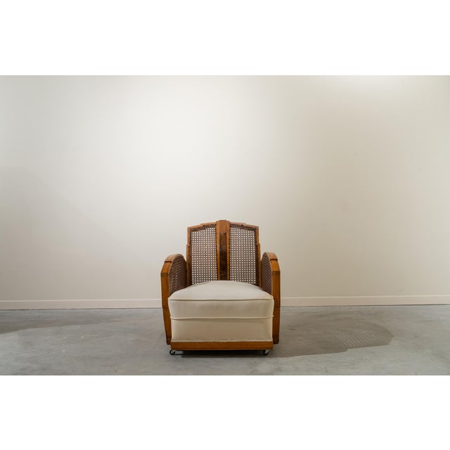 French armchairs in cane and walnut wood from the 1930s. Wooden frame, cane panels, and upholstered cushion on four...