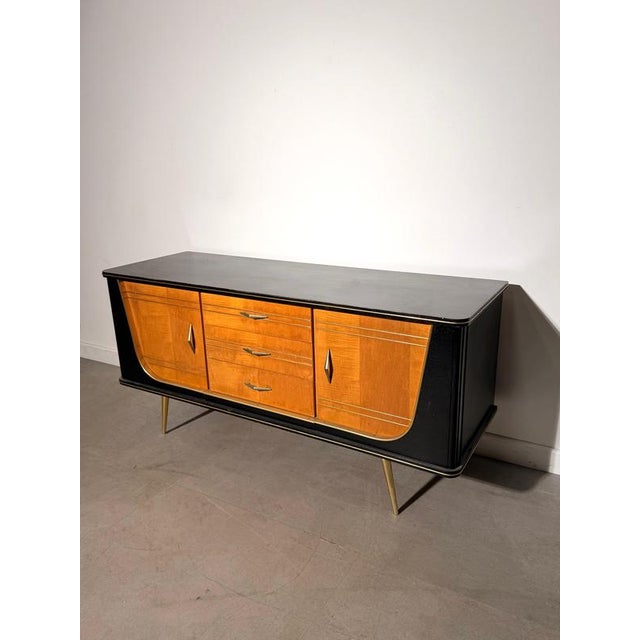 Striking 1950s rockabilly sideboard with a characteristic mid-century design combining warm wood tones, a contrasting...