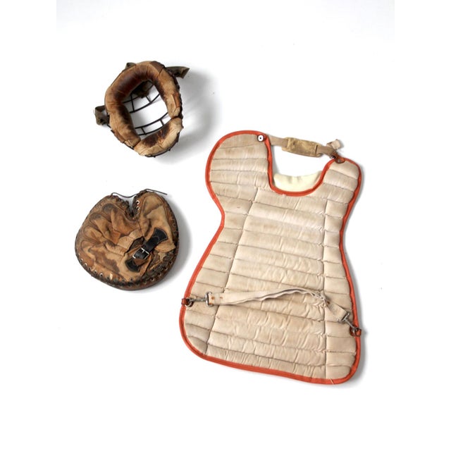 A collection of vintage baseball catcher's equipment dating from approximately the 1930s–1950s. This grouping includes a...
