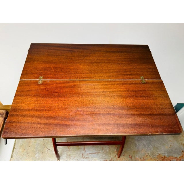 Folding wooden coaching table with curved X-form legs, turned stretcher, and brass hardware. The proportions and folded...