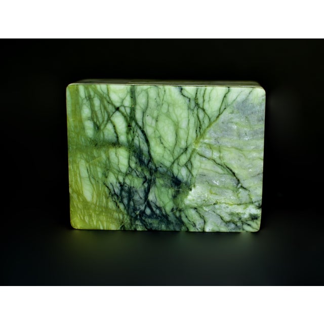 A rare and finely crafted rutile serpentine stone box, showcasing vivid green tones animated by striking veining and dark...