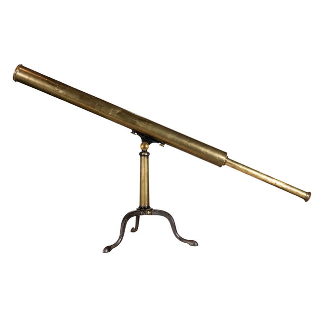 Brass telescope. Low-set metal tripod feet and singular central pillar.