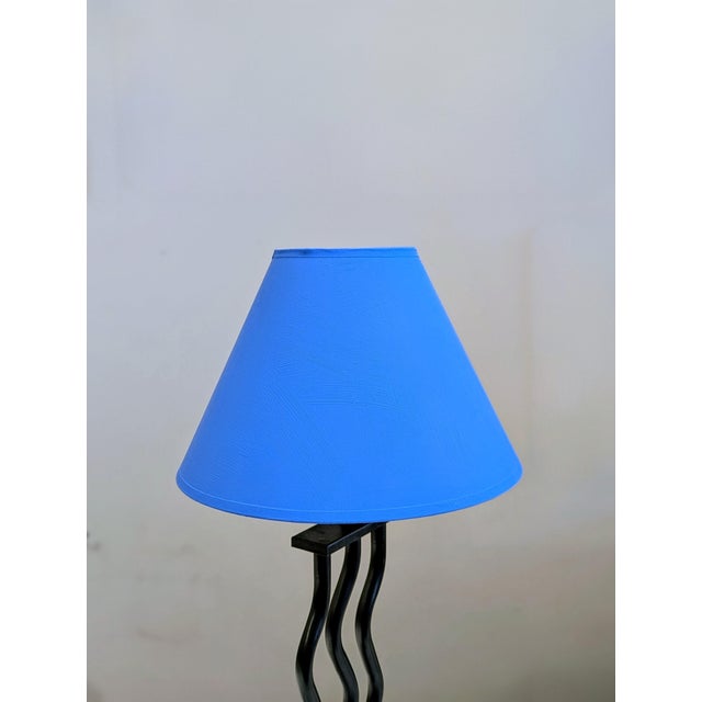 A character-driven table lamp from the 1990s, reflecting the playful influence of Memphis Milano. The sculptural black...