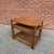 Pair of vintage nesting end tables with woven cane inset lower shelves and a warm oak-toned finish. The larger table...