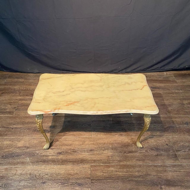 Elegant French antique marble top coffee table with sculpted fitted marble resting on gilt metal cabriole legs. The cream...